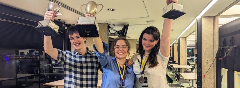 Lachie Doyle holding his Novice Best Speaker trophy, Liv Bishara holding the Australian Intervarsity Debating Championship trophy and Conna Leslie-Keefe holding her Overall Best Speaker trophy