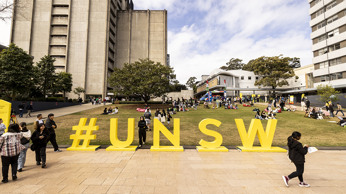 View towards UNSW library of lawn with a sign that says #UNSW