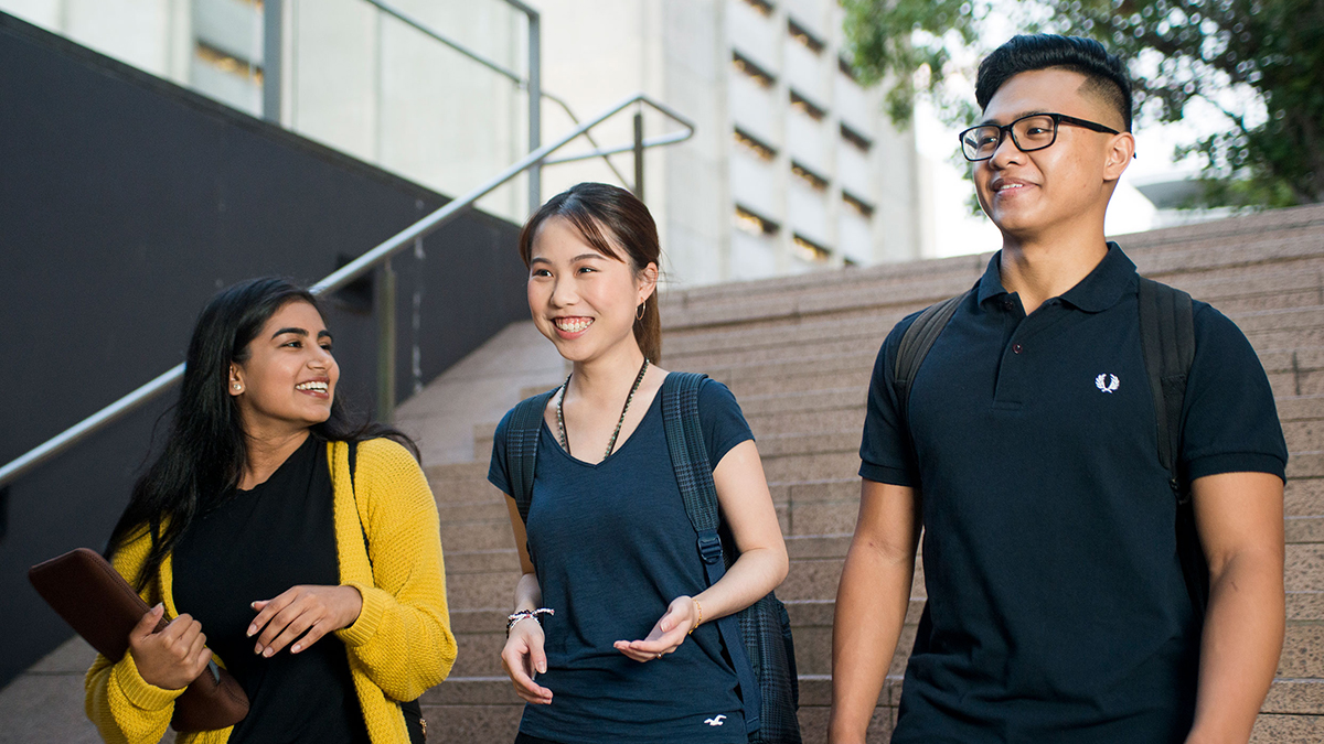 Three students walking down stairs