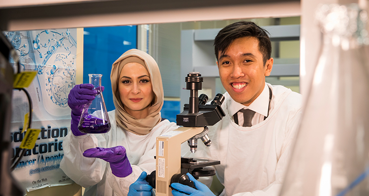 Two smiling researchers in a laboratory