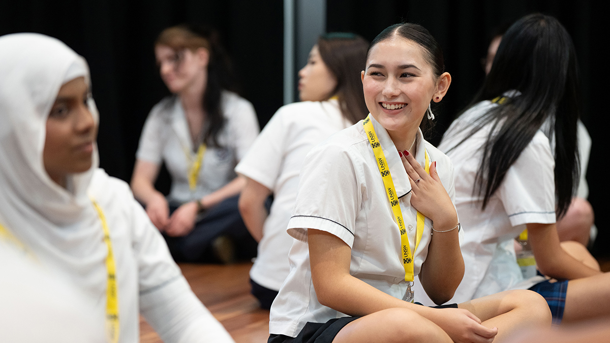 A high school student smiling at another student