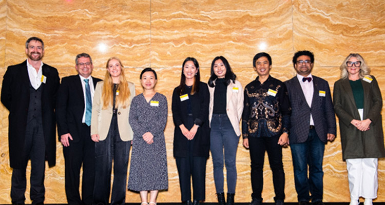 A group of people standing in front of a wall