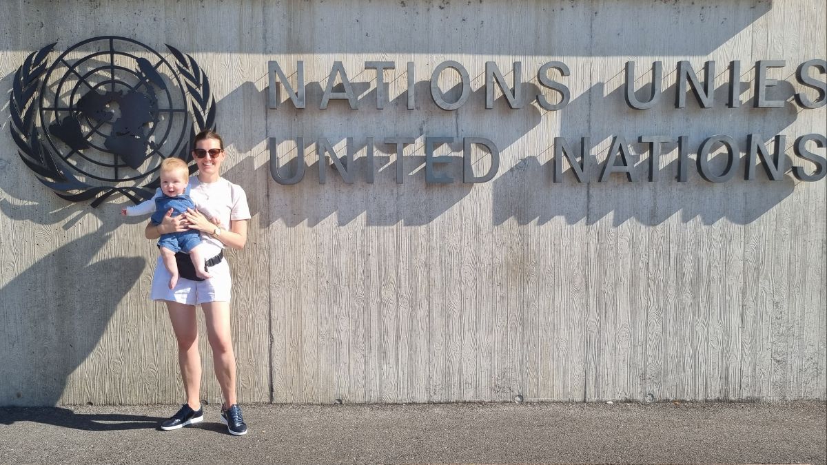 Woman holds child before United Nations building