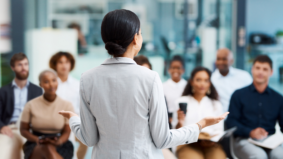 Woman giving presentation to group of staff