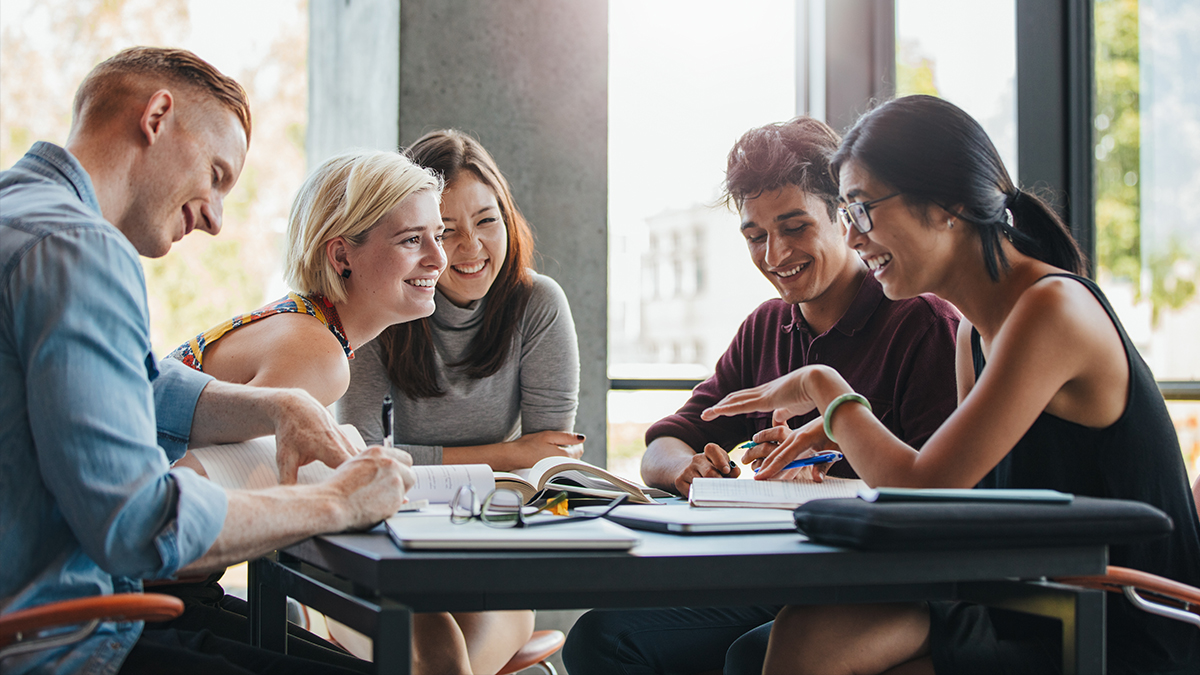 A group of uni students having a discussion around a table