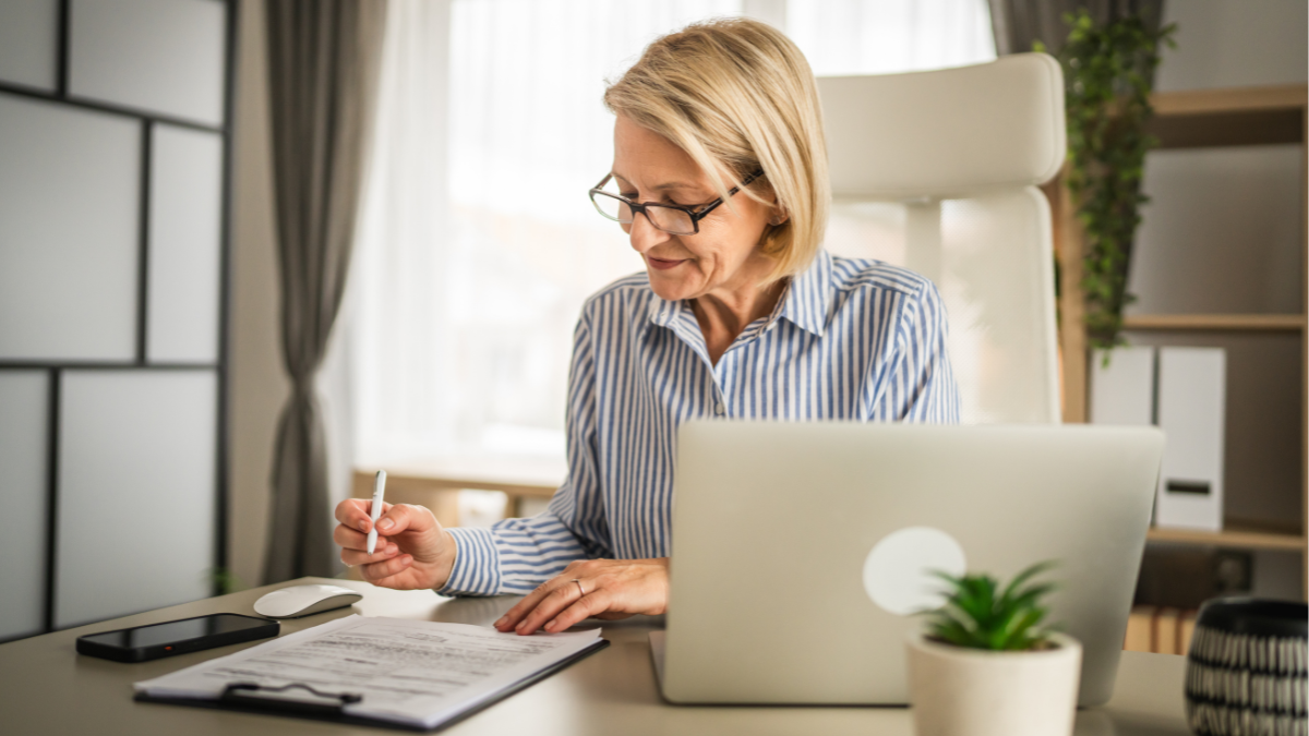 A woman writing her Will at a desk.