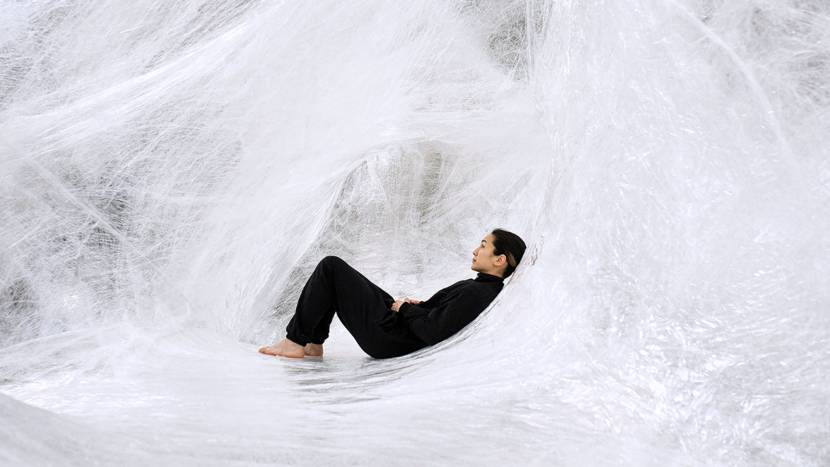 A woman wearing all black cocooned in a white web