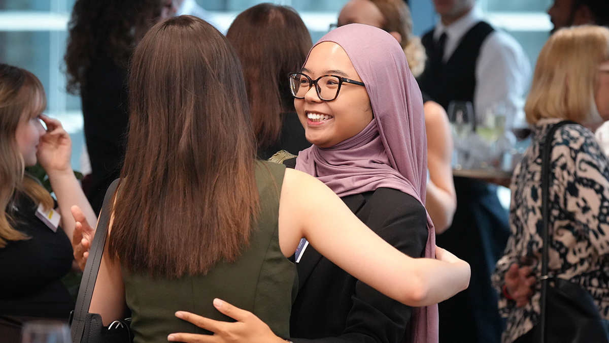 Two students embracing and smiling