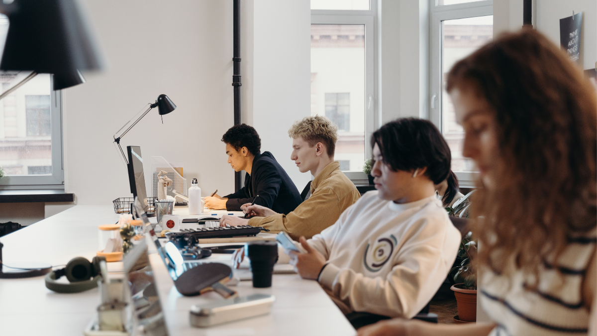 Four staff members sitting a desk working