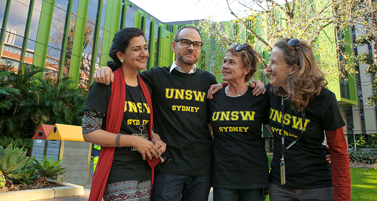 Four smiling people standing in front of Wallace Wurth building