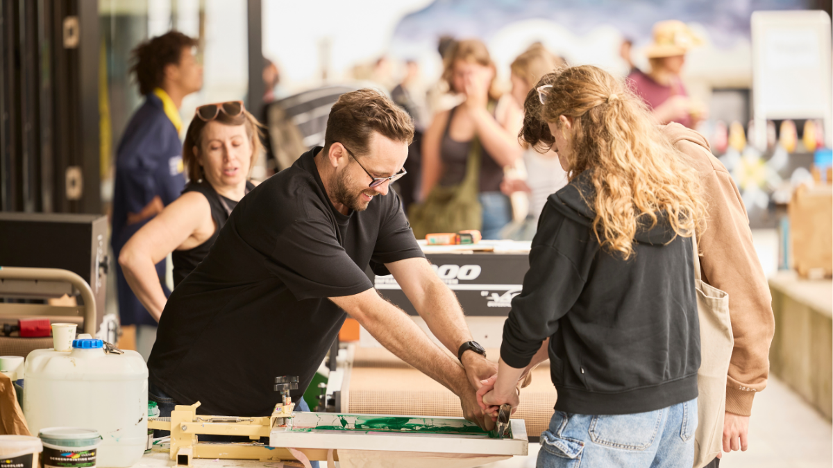 A man helping people screenprint