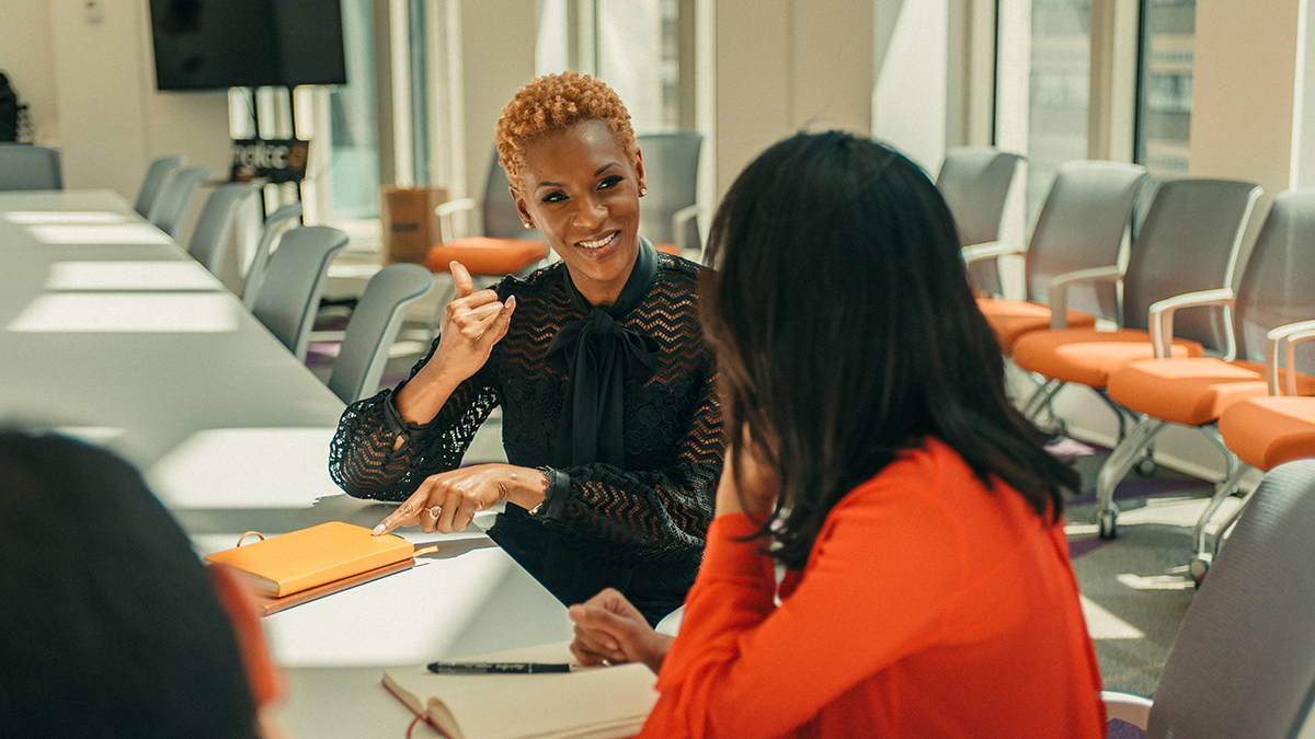 Two women talking in a boardroom