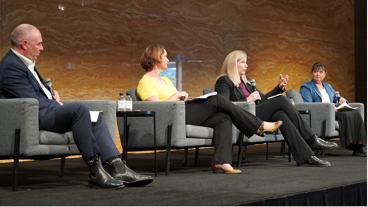 Four people in armchairs on a stage