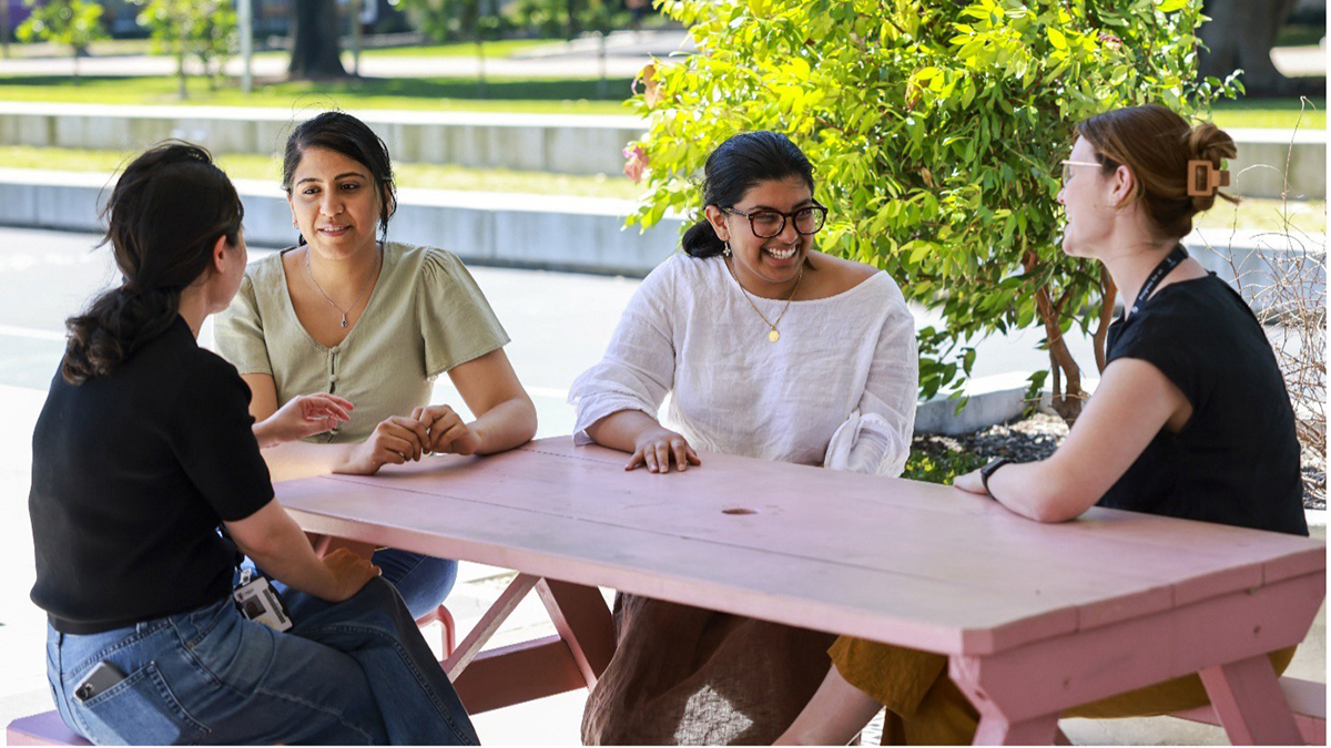 A group of women at a table outside talking