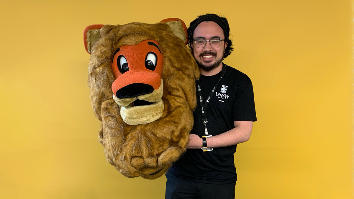 A young man holds a lion's head costume