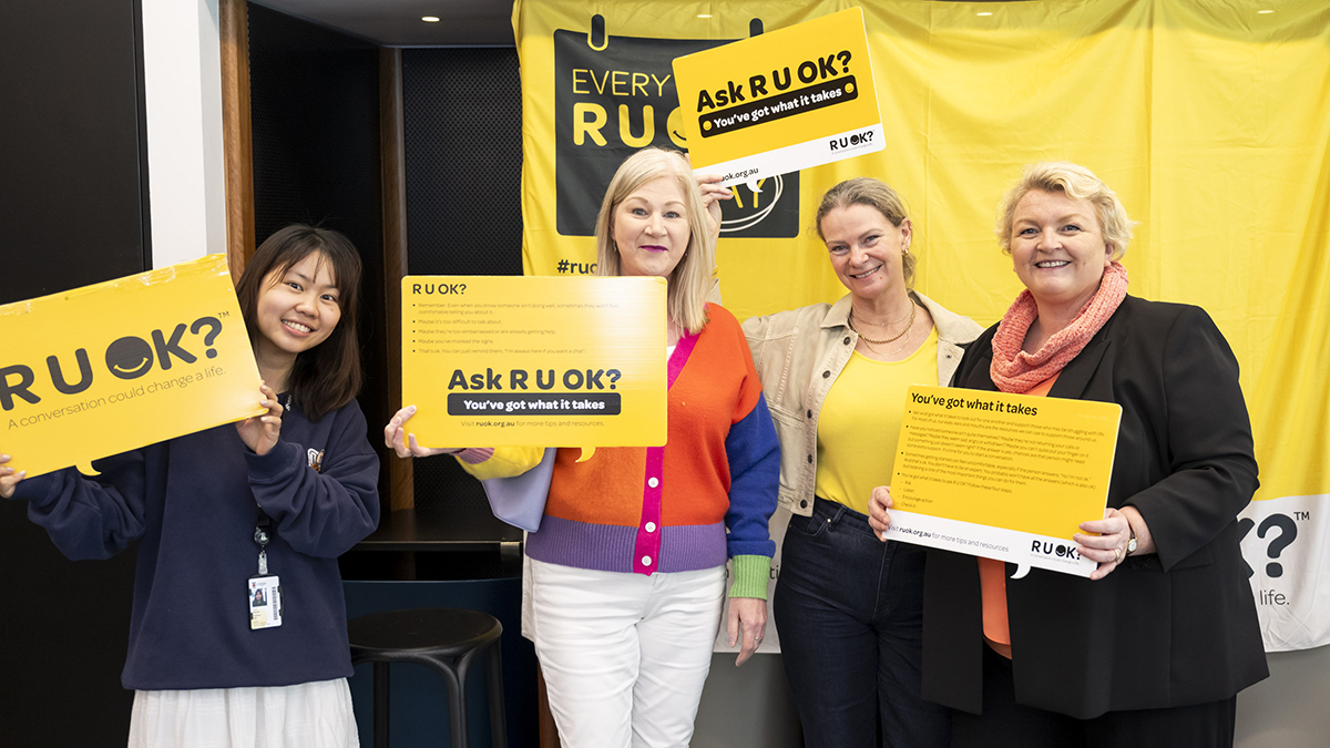 Four women holding R U Ok? Day signs
