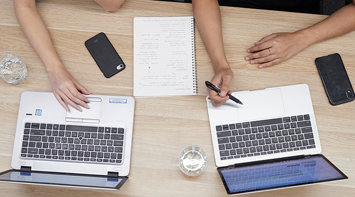 Two laptops on a wooden table
