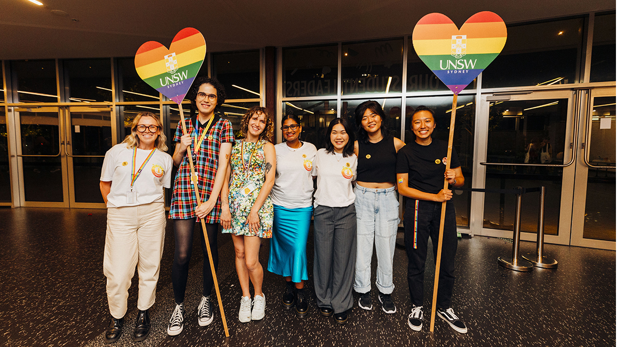 UNSW staff holding rainbow flag hearts at the Minus18 Queer Formal