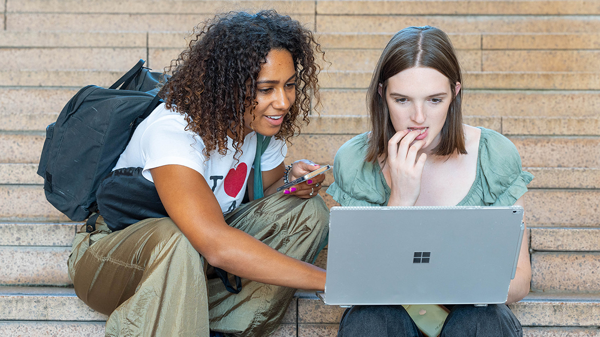 Two students looking at a laptop