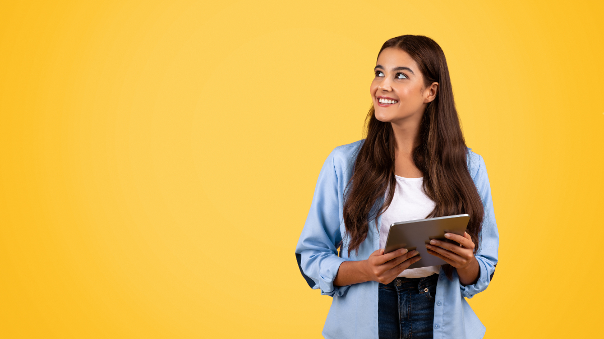 A woman on an ipad on a yellow background.