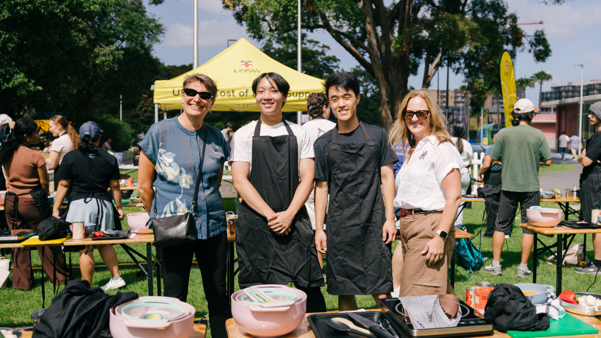 Four people from Arc standing in front of cooking materials on the UNSW campus.