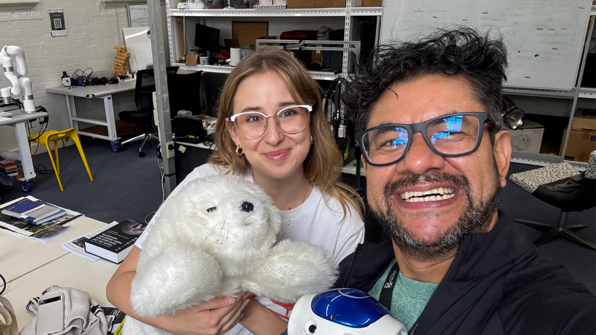 Eduardo and a co-worker with the robots.