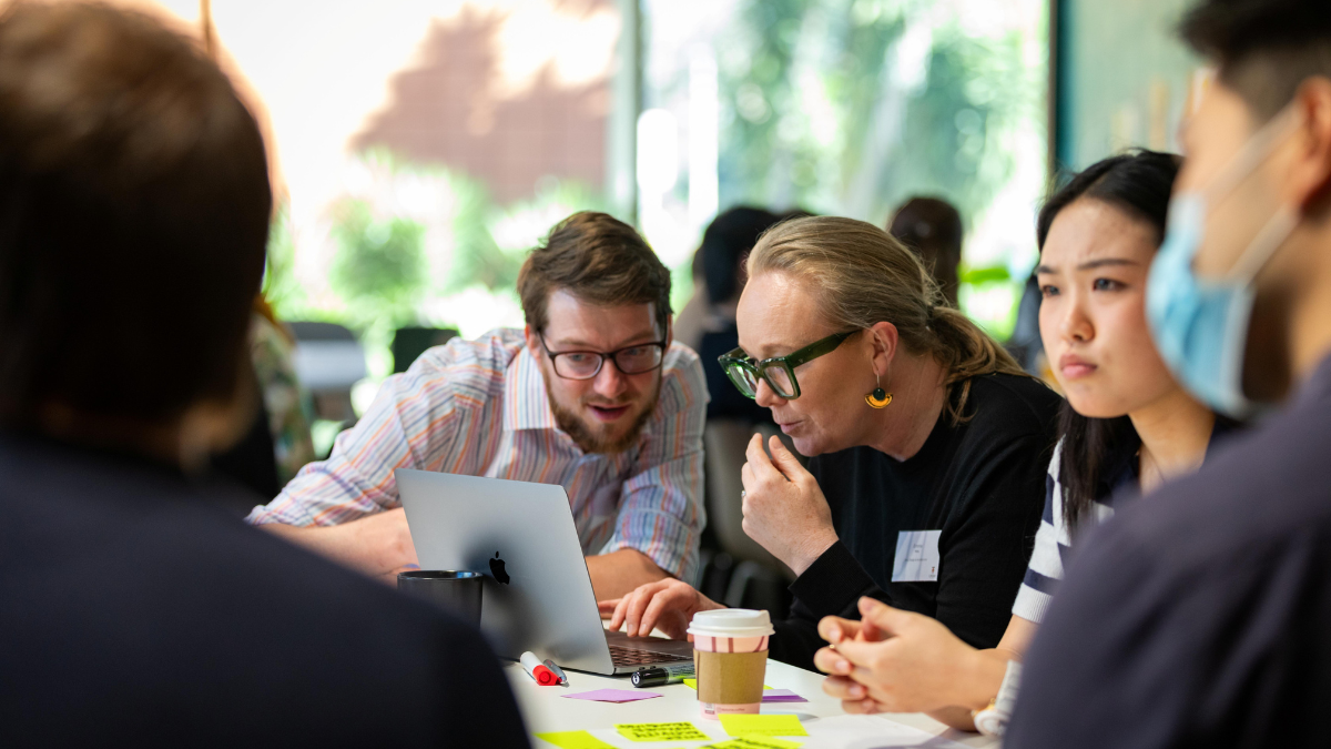 Staff around a table looking at a laptop.
