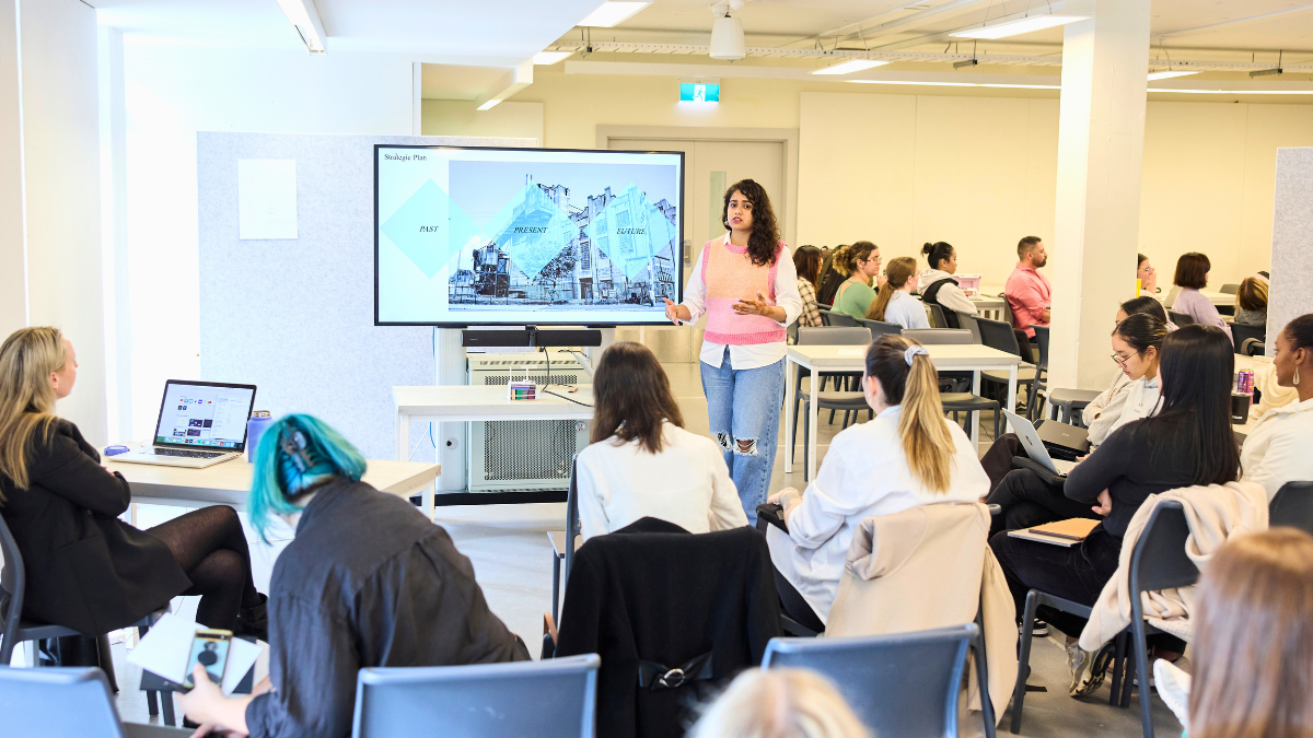 A woman presenting a project to her class.