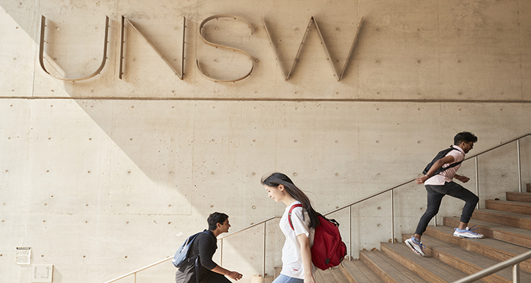 Students walking past UNSW sign