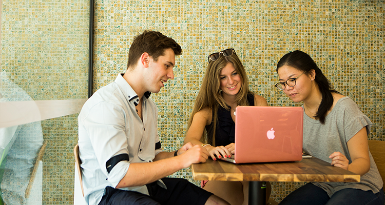 Three UNSW students sitting around a laptop