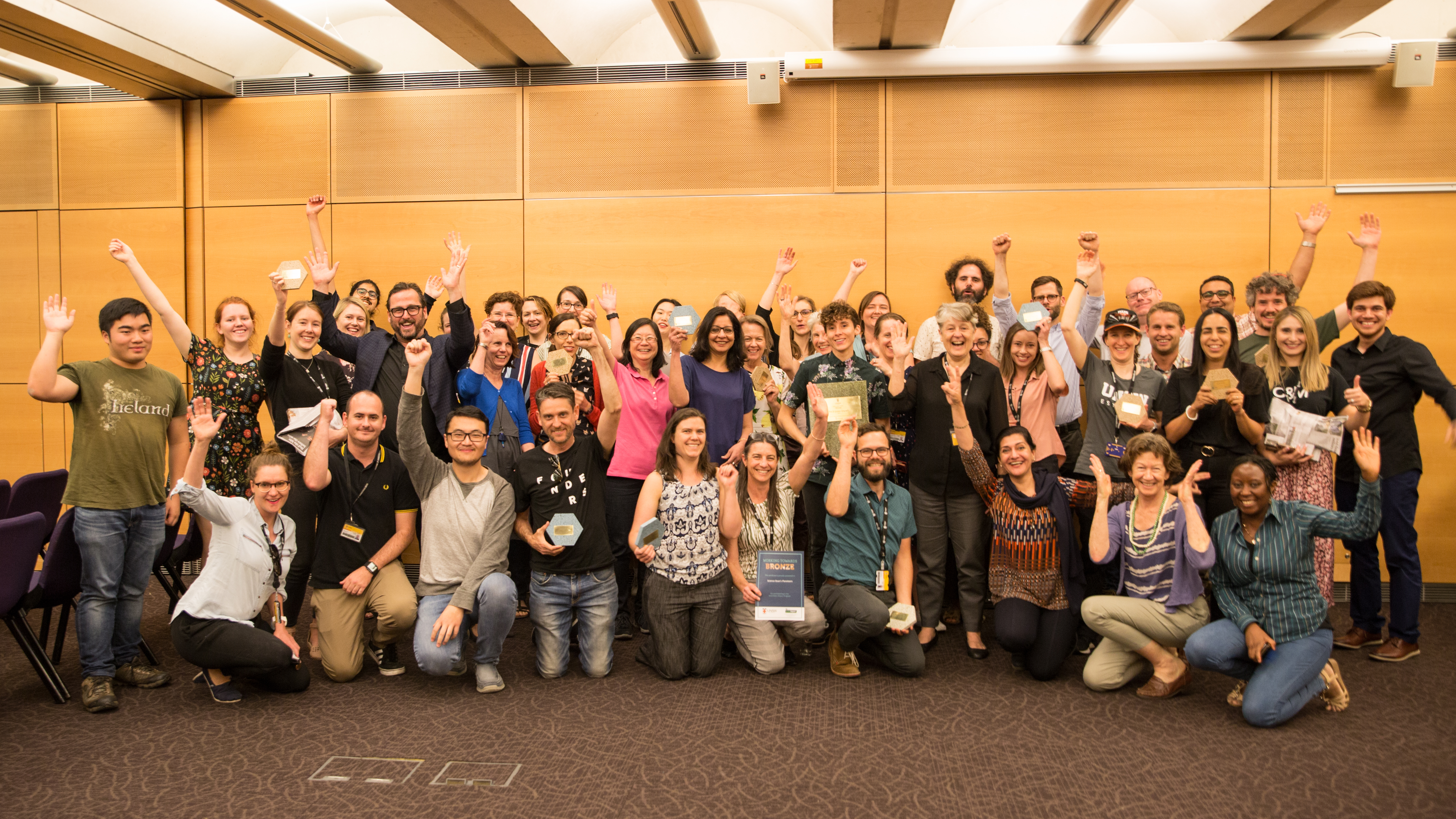 A crowd of Green Impact participants waving