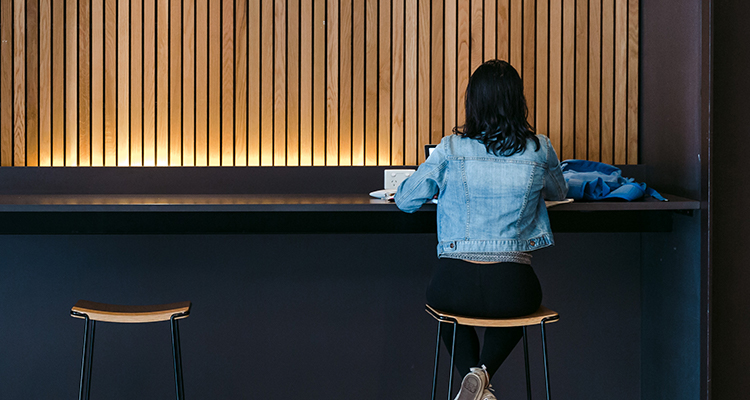 Woman sitting on a stool at a bench