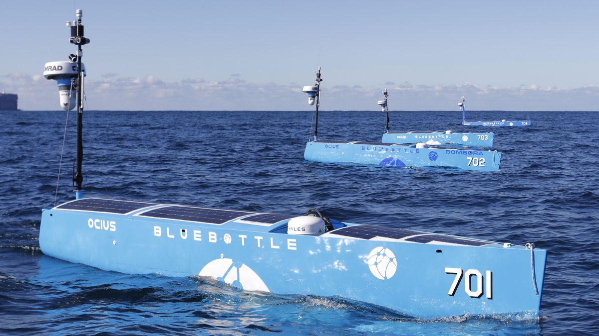 Three blue unmanned robot boats on the open ocean