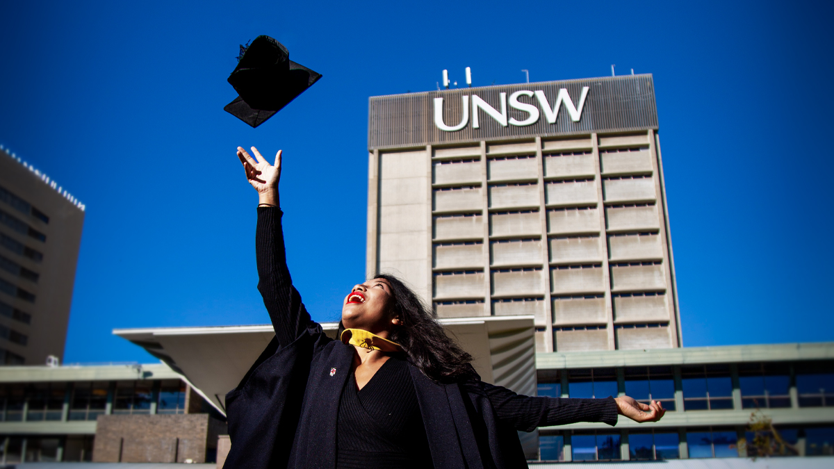 Student throwing their hat at graduation on Library Lawn