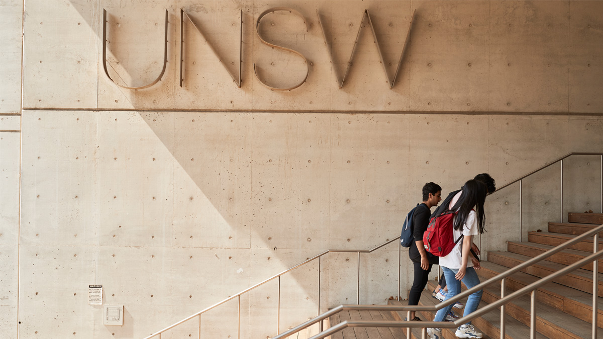 People walking up steps with UNSW logo in backgroun