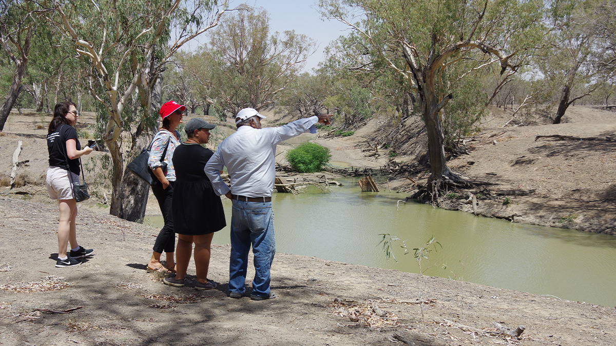 Dharriwaa Elders Group speaker Clem Dodd, Yuwaya Ngarra-li’s Peta MacGillivray and Professor Jacqui Webster and Keziah Bennett-Brook from the George Institute for Global Health standing around a lake in Walgett