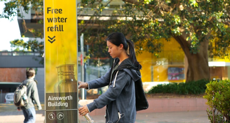 student filling up water bottle at refill station