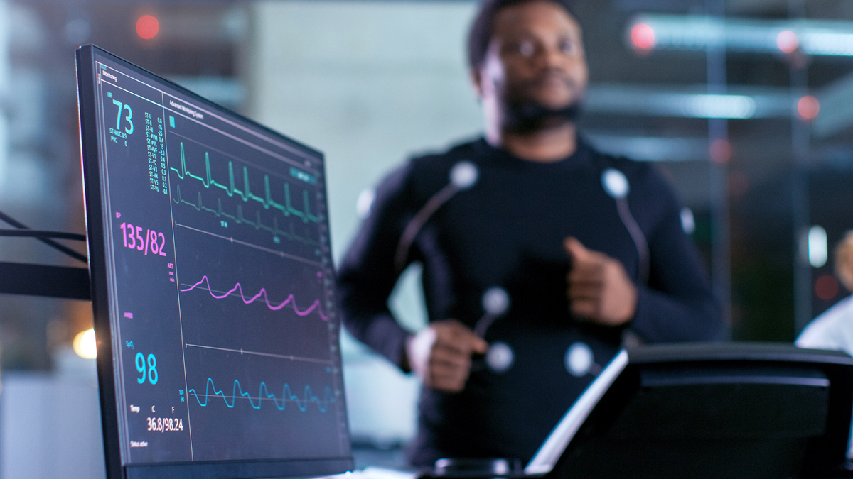 A man on a running machine with monitors attached 