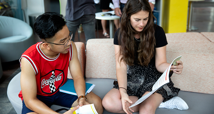 Two students reading a booklet