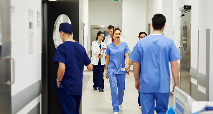 Medical staff wearing scrubs in a hospital corridor