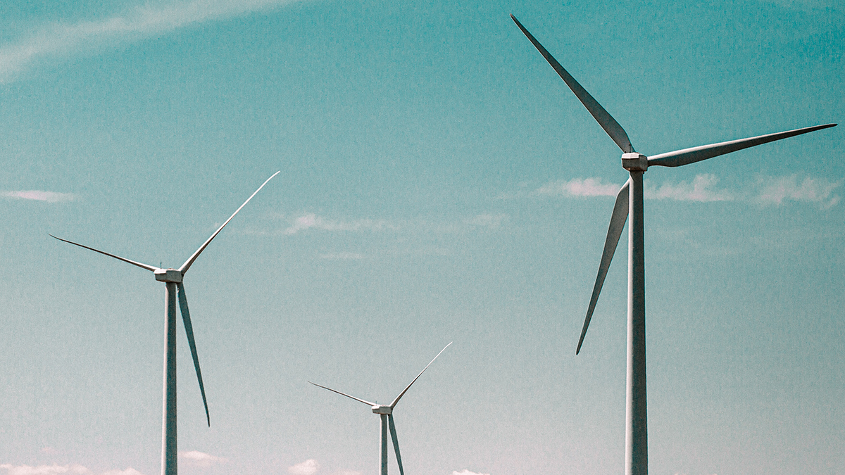 Three wind turbines against a blue sky