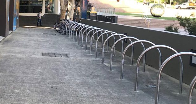 curved metal bike racks on a concrete ground