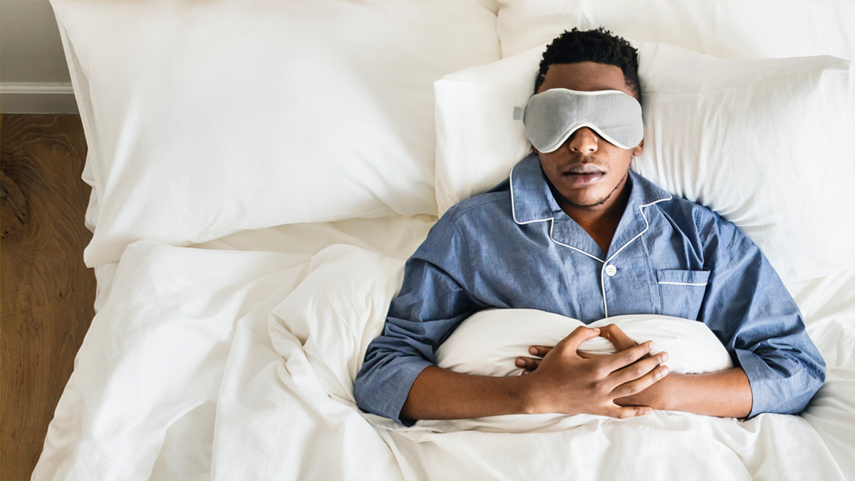 A man sleeping with an eye mask