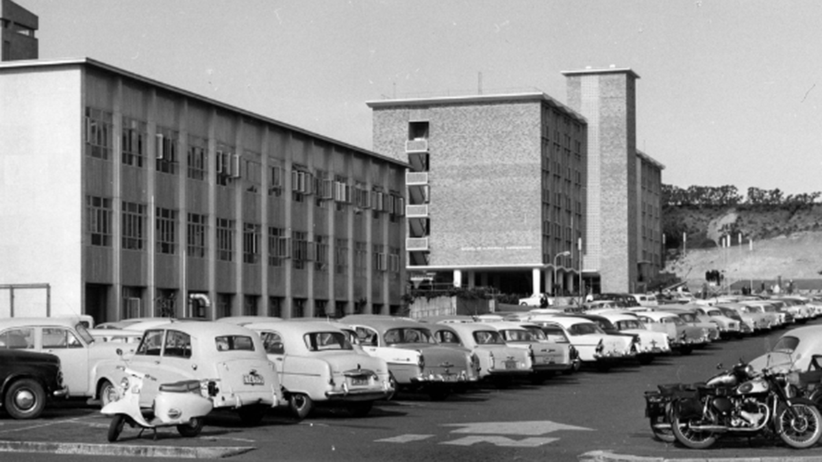 Black and white photo of cars parked outside building