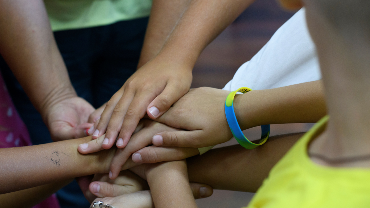 Close up on a group with their hands together