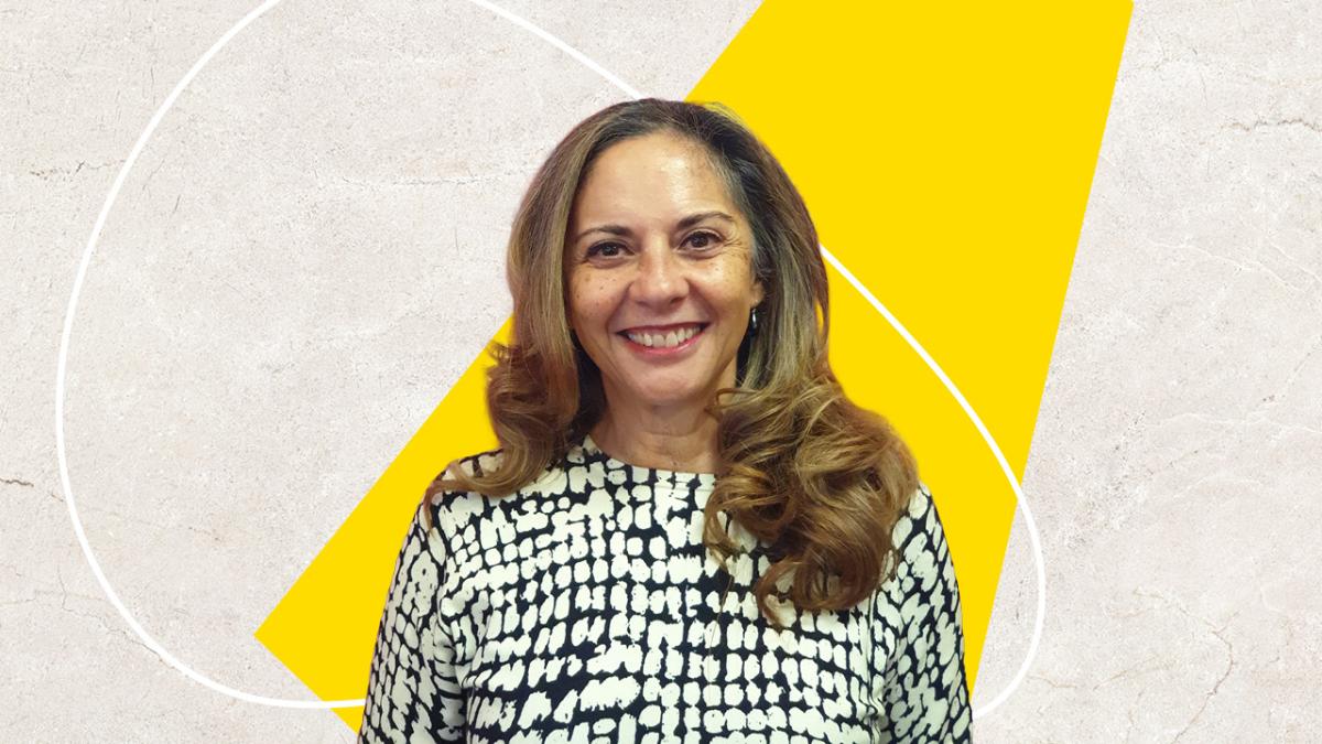 A woman with long light brown hair against a yellow and beige background