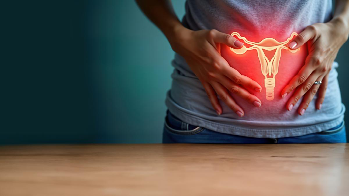 Close up of person with hands on their stomach and a glowing female reproductive system overlaid