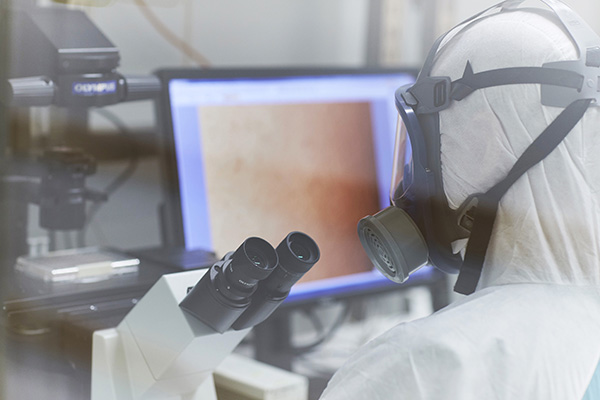 Stuart Turville examining the SARS-CoV-2 virus through the microscope