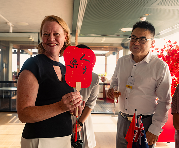 A man and a woman holding a red fan