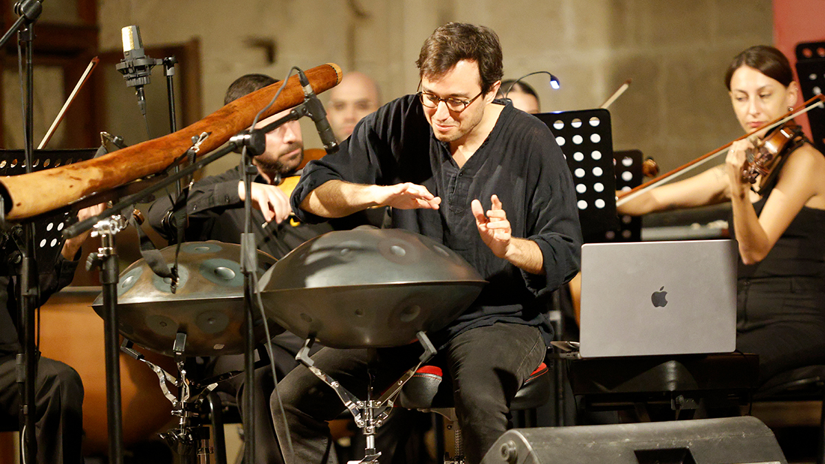 Baran Yildiz playing the handpan with an orchestra.